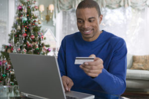 Man with credit card and laptop making purchases on Black Friday